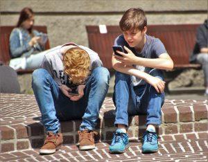 Two boys looking at their cell phones